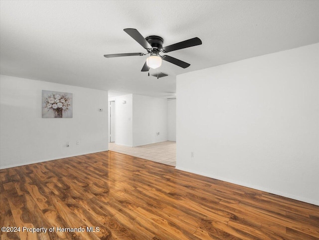 unfurnished room featuring a textured ceiling, light wood-type flooring, and ceiling fan