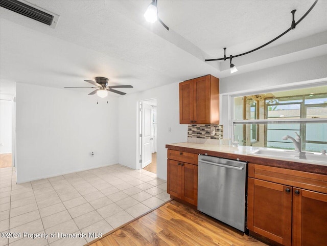 kitchen with backsplash, a textured ceiling, light tile patterned floors, sink, and dishwasher