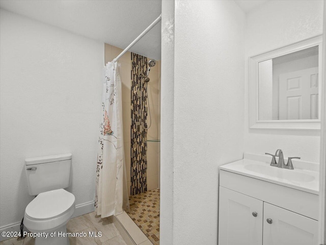 bathroom featuring toilet, a shower with curtain, vanity, and tile patterned floors