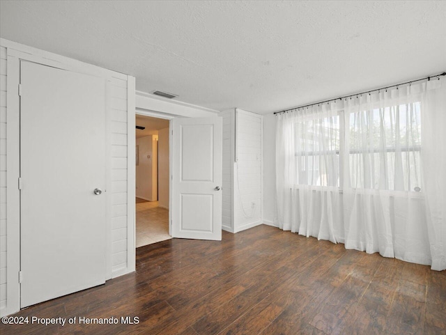 spare room with dark wood-type flooring and a textured ceiling