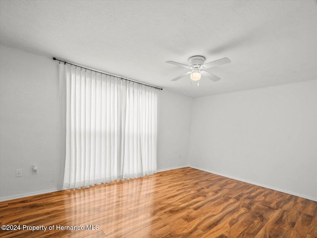 spare room with hardwood / wood-style floors, ceiling fan, and a textured ceiling