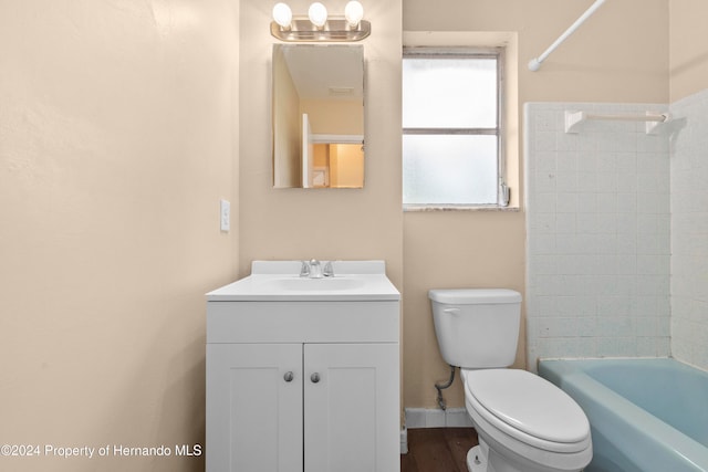 full bathroom featuring toilet, vanity, hardwood / wood-style floors, and tiled shower / bath