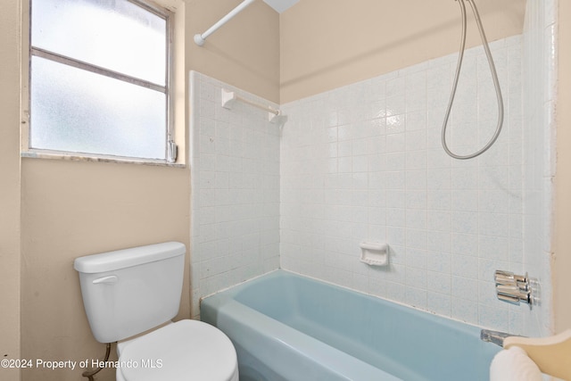 bathroom featuring a wealth of natural light, tiled shower / bath combo, and toilet