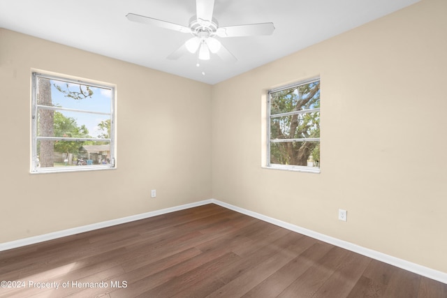 empty room with hardwood / wood-style flooring, ceiling fan, and a healthy amount of sunlight