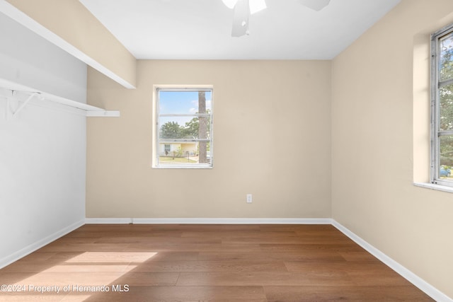 unfurnished room with a wealth of natural light, ceiling fan, and hardwood / wood-style flooring