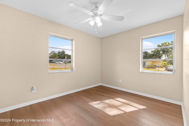 empty room featuring hardwood / wood-style floors, ceiling fan, and plenty of natural light