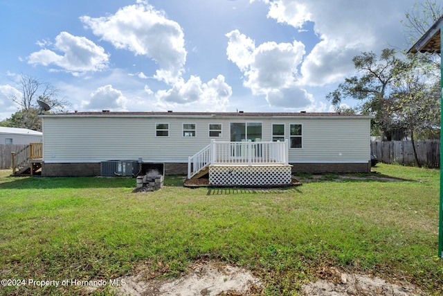 back of house with a deck, central AC unit, and a lawn