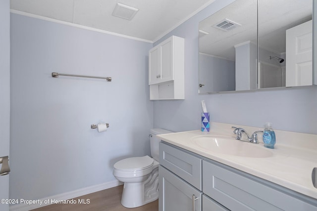 bathroom featuring walk in shower, hardwood / wood-style floors, toilet, vanity, and ornamental molding