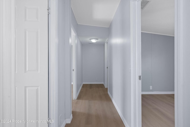 hallway with light hardwood / wood-style floors