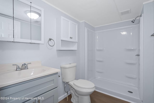 bathroom with a shower, wood-type flooring, toilet, vanity, and ornamental molding