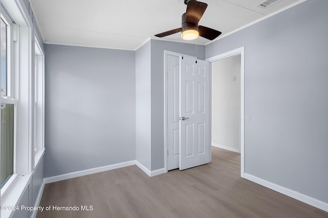 unfurnished bedroom featuring ceiling fan, light hardwood / wood-style floors, and ornamental molding