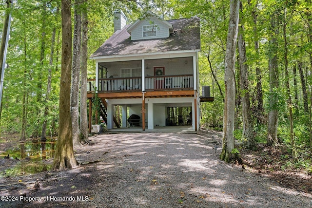 view of front of house featuring a sunroom, cooling unit, and a carport