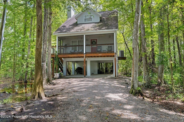7413 Gettysburg Dr, Weeki Wachee, FL 34607 - coastal inspired home featuring a carport, a chimney, driveway, cooling unit, and roof with shingles