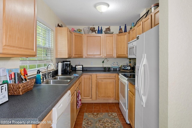 kitchen with a textured ceiling, white appliances, light brown cabinetry, and sink