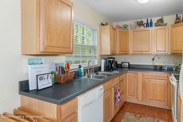 7413 Gettysburg Dr, Weeki Wachee, FL 34607 - kitchen featuring white appliances, a sink, dark countertops, dark tile patterned floors, and light brown cabinetry