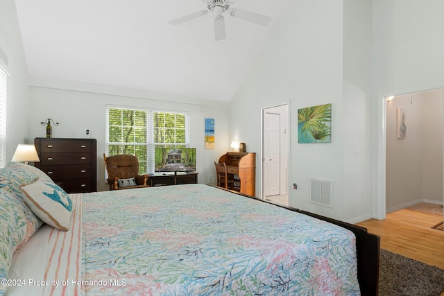 bedroom with hardwood / wood-style floors, high vaulted ceiling, and ceiling fan