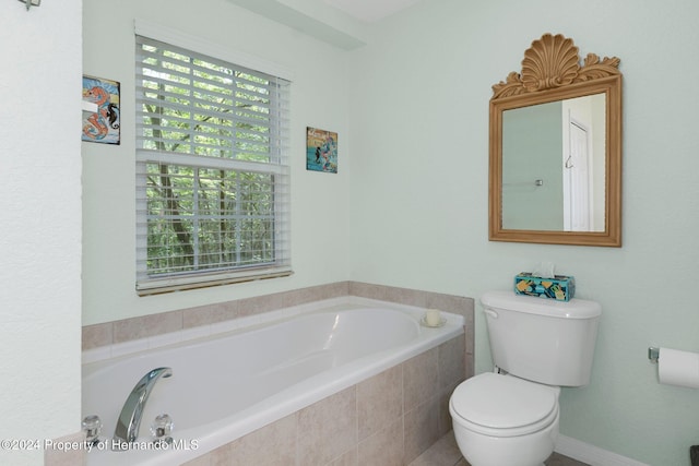 bathroom with toilet and tiled tub