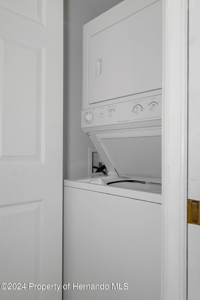 washroom featuring stacked washer / dryer