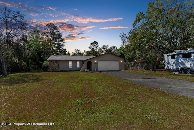 single story home with a garage and a yard