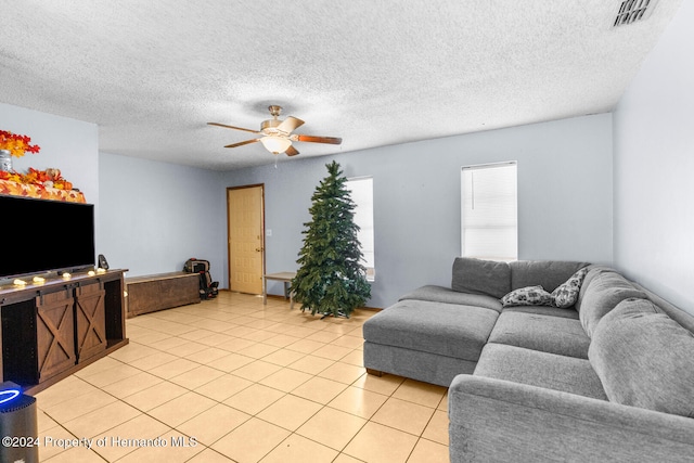 living room featuring light tile patterned floors, a textured ceiling, and ceiling fan