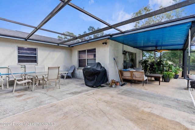 view of patio with area for grilling, ceiling fan, and a lanai