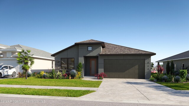 view of front of property featuring a front lawn and a garage