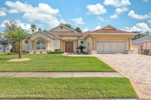 view of front of home with a front yard and a garage