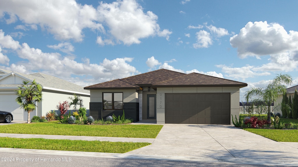 view of front of home with a front lawn and a garage