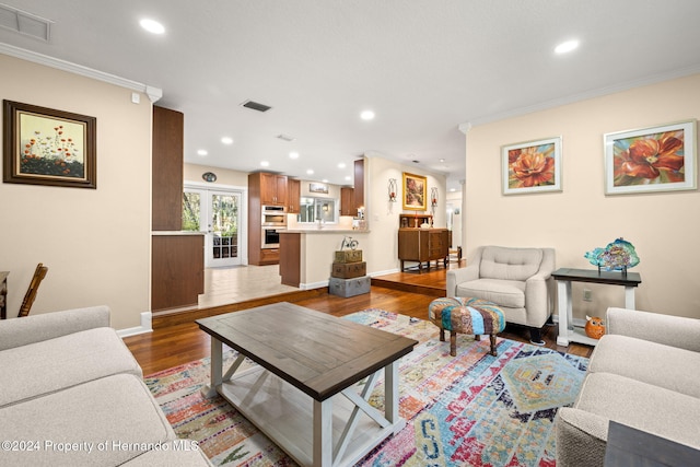 living room featuring french doors, hardwood / wood-style flooring, and crown molding