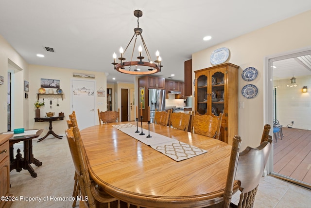 dining space with light tile patterned floors and an inviting chandelier