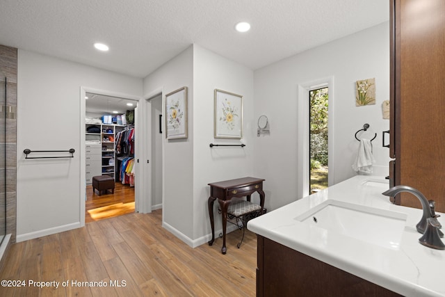 bathroom featuring hardwood / wood-style floors, vanity, and a textured ceiling