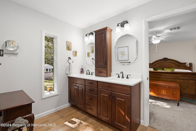 bathroom featuring ceiling fan, hardwood / wood-style floors, vanity, and a textured ceiling