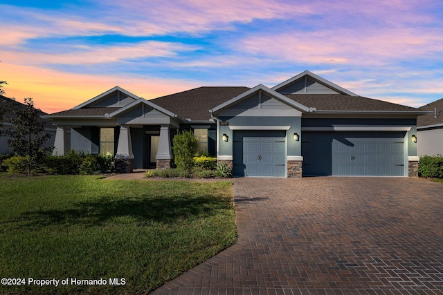 craftsman inspired home with a lawn and a garage