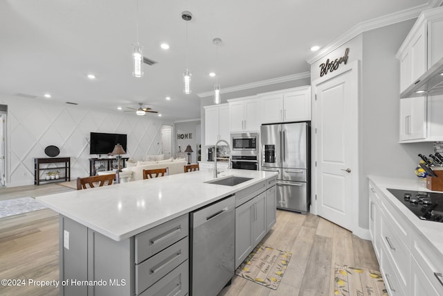 kitchen with sink, stainless steel appliances, an island with sink, light hardwood / wood-style floors, and decorative light fixtures