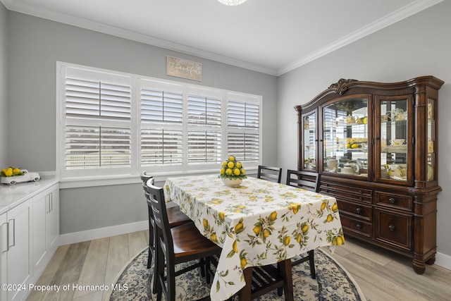 dining area with light hardwood / wood-style floors, ornamental molding, and a wealth of natural light