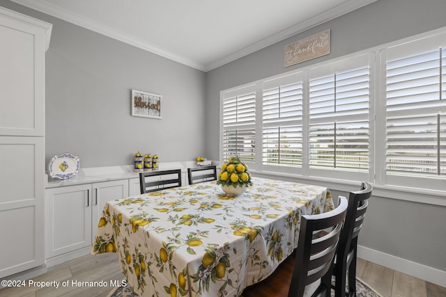 dining area with crown molding and light hardwood / wood-style flooring