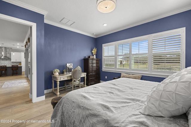 bedroom with light wood-type flooring and ornamental molding