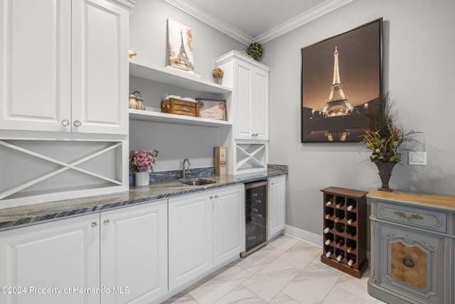 bar featuring dark stone counters, white cabinets, crown molding, sink, and beverage cooler