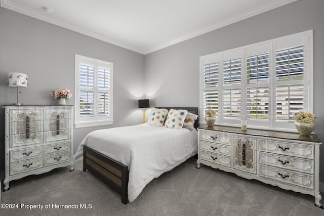 bedroom with crown molding and dark colored carpet