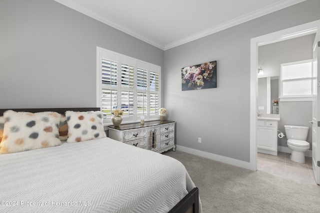 carpeted bedroom with crown molding and ensuite bath