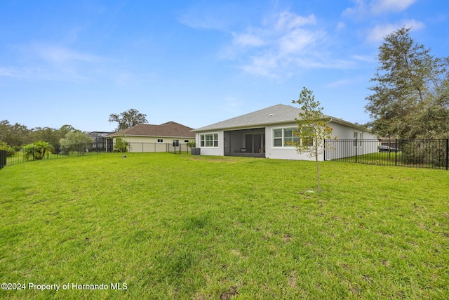 back of property with a sunroom and a yard