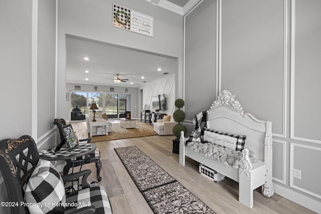 interior space with ceiling fan, light hardwood / wood-style flooring, and ornamental molding