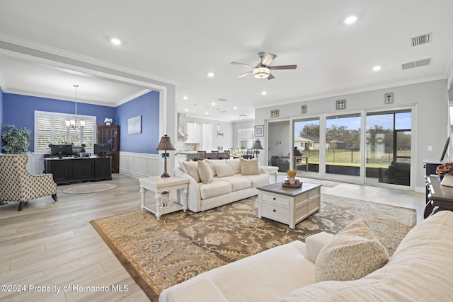 living room with ceiling fan with notable chandelier, light wood-type flooring, and ornamental molding