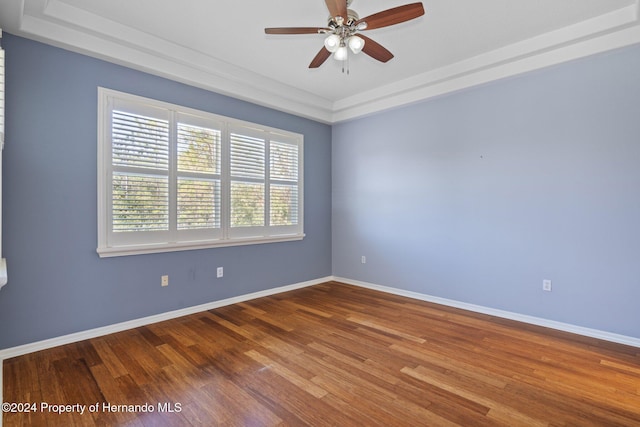 unfurnished room featuring a tray ceiling, hardwood / wood-style flooring, and ceiling fan