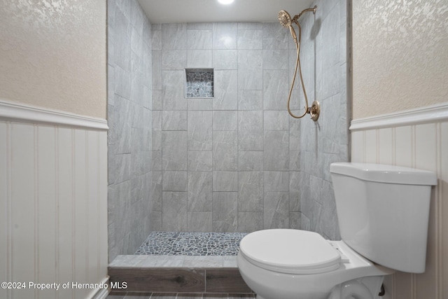 bathroom featuring a tile shower and toilet