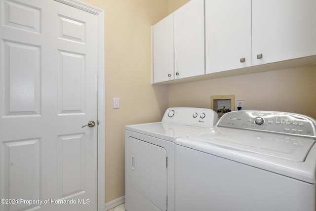 washroom featuring cabinets and separate washer and dryer