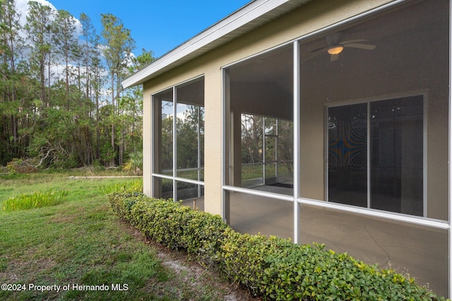 view of side of property featuring ceiling fan and a sunroom