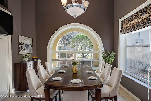 tiled dining space with an inviting chandelier