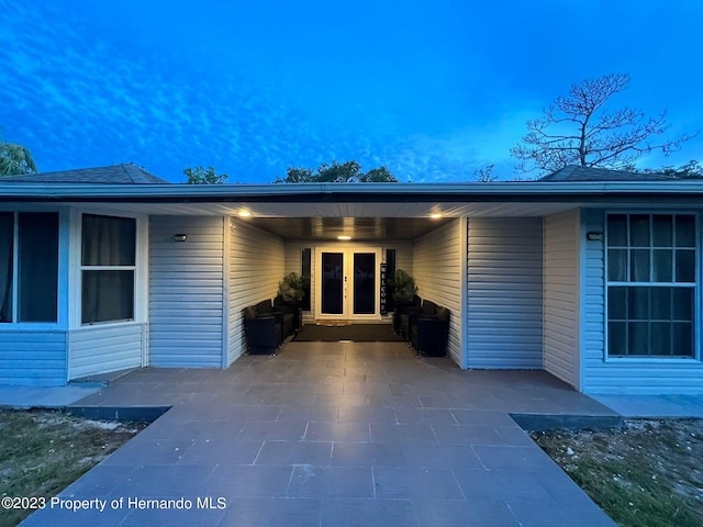 exterior entry at dusk featuring french doors