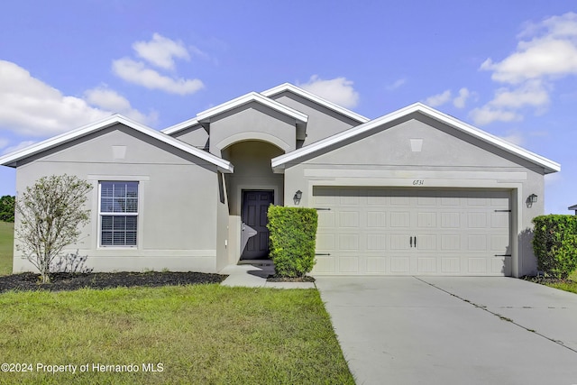 view of front of property featuring a garage and a front yard